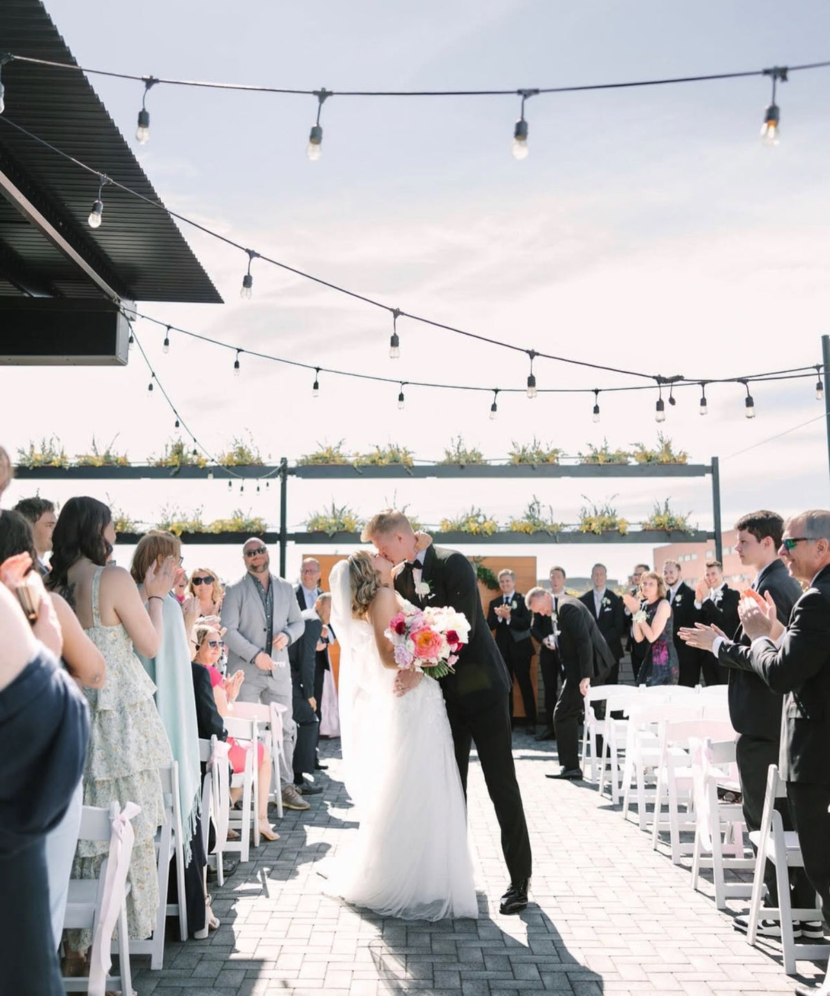 Wedding couple kissing in the aisle on the rooftop of Port 393
Photo by AES Photography (aes.photography)
